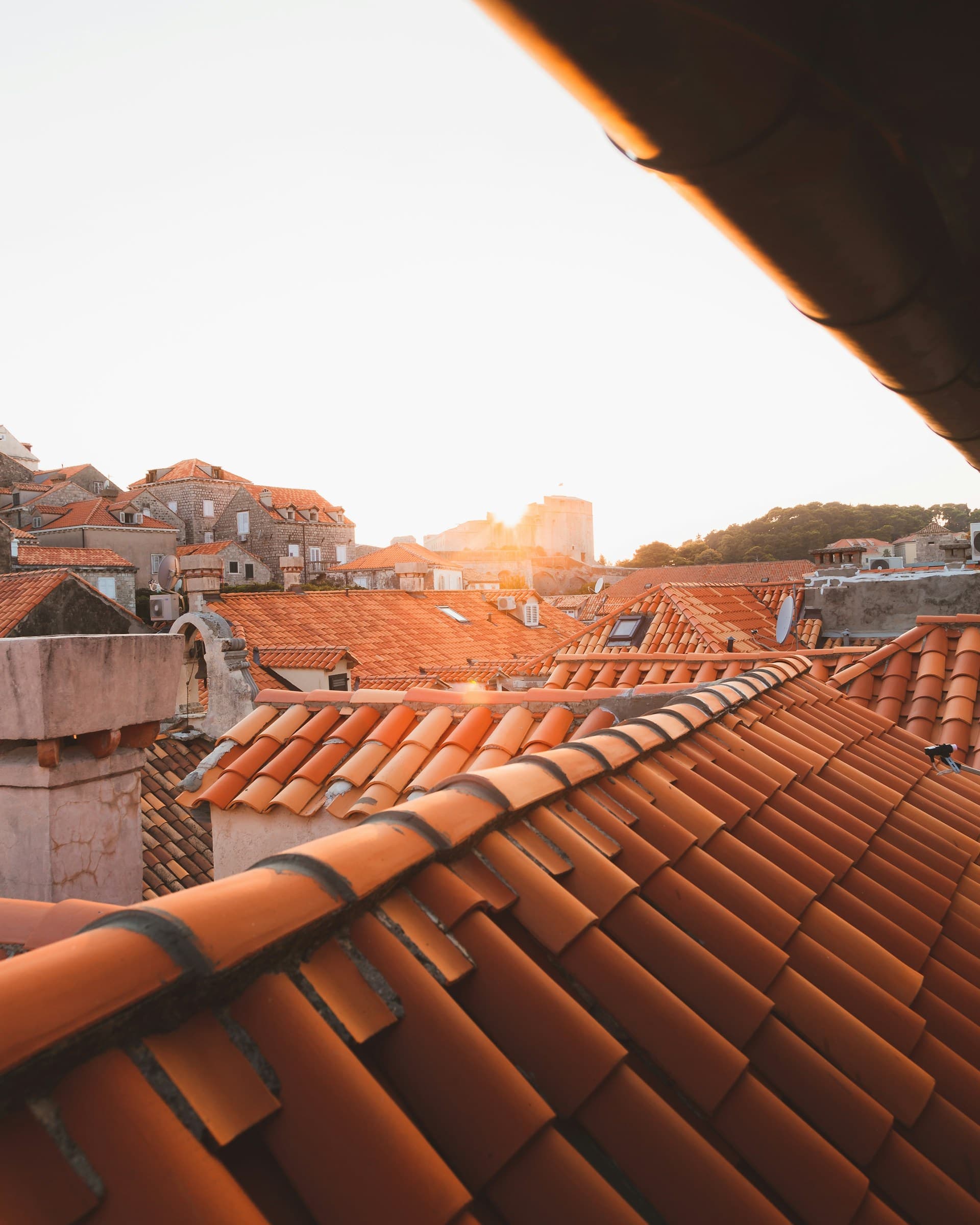 Çati me tjegulla terrakotë të një qyteti mesdhetar në dritën e artë